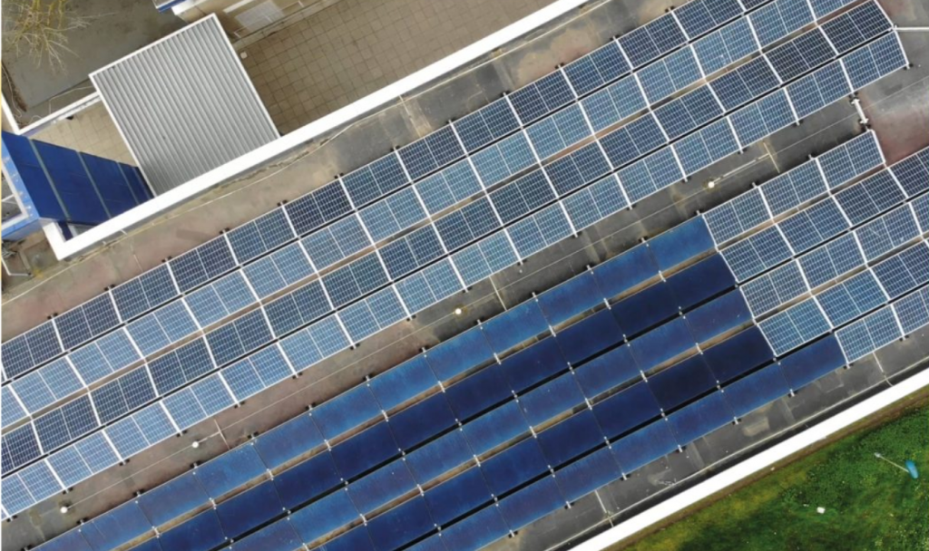 An aerial shot of solar panels on the roof of a school